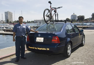 Photo of County employee standing next to a County car powered by used vegetable oil.